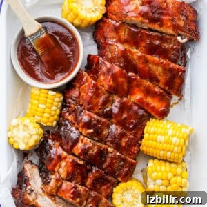 bbq ribs and corn on the cob with bbq sauce.