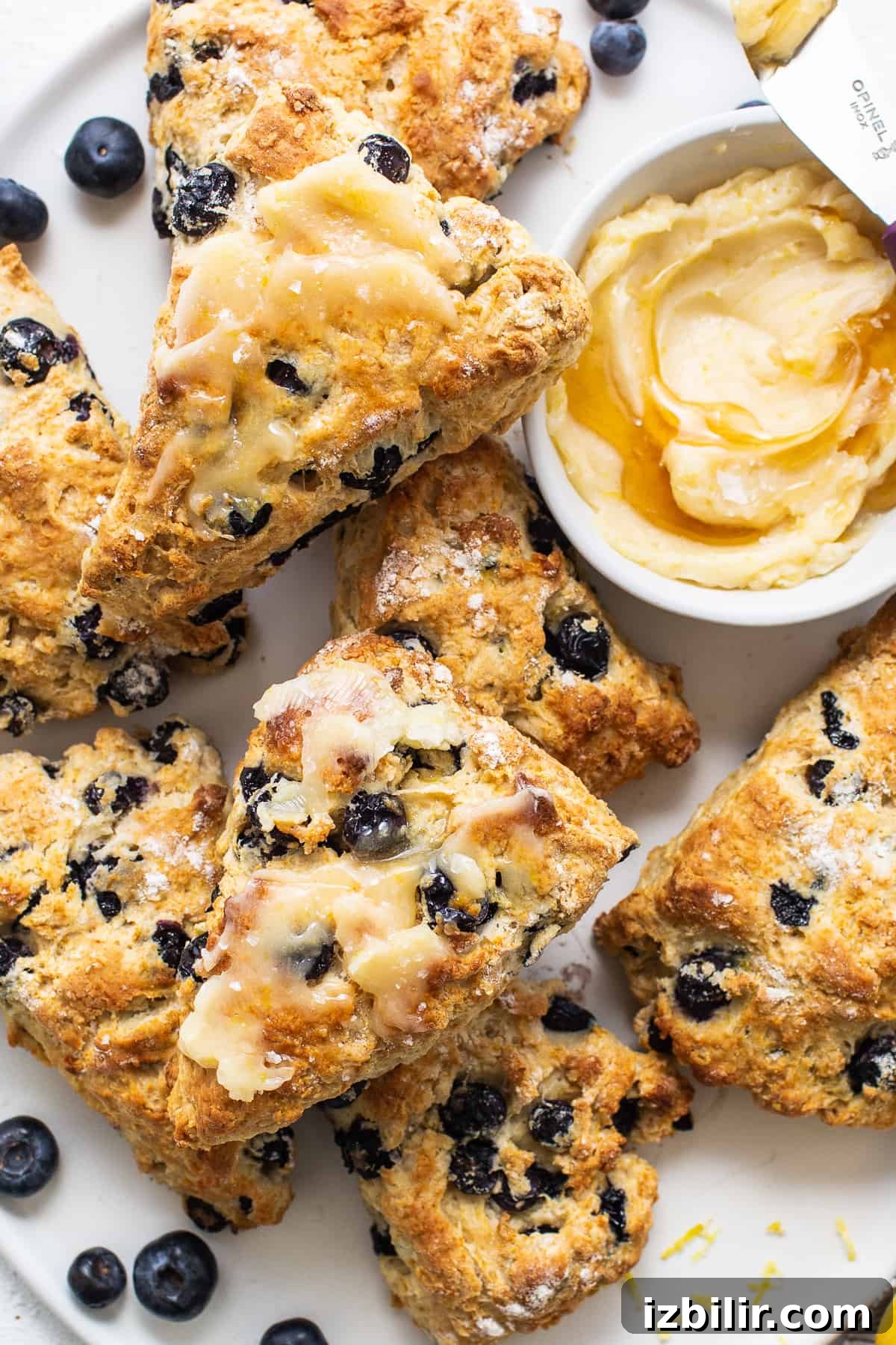 a white plate topped with scones and blueberries.