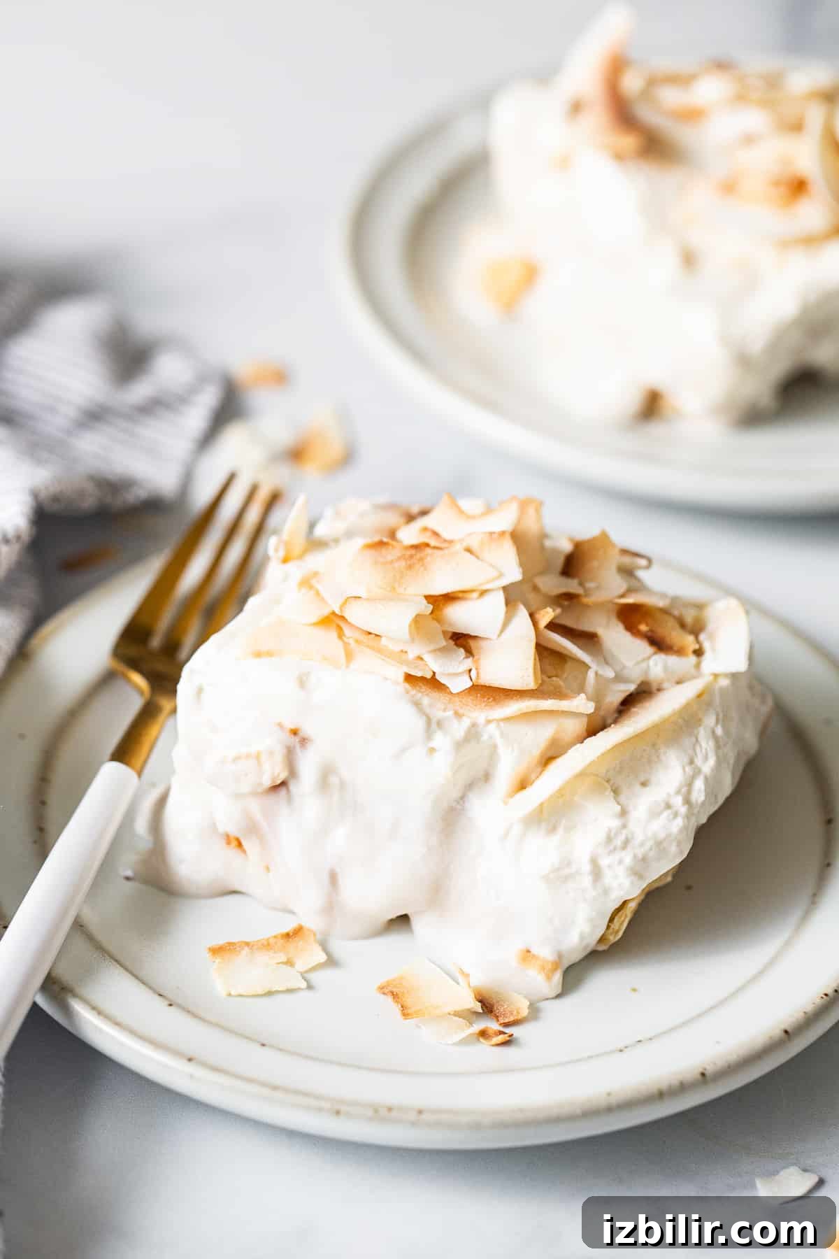 Coconut Cream Pie Bars with Toasted Coconut Topping 2 A white plate topped with a piece of coconut cream pie bar.