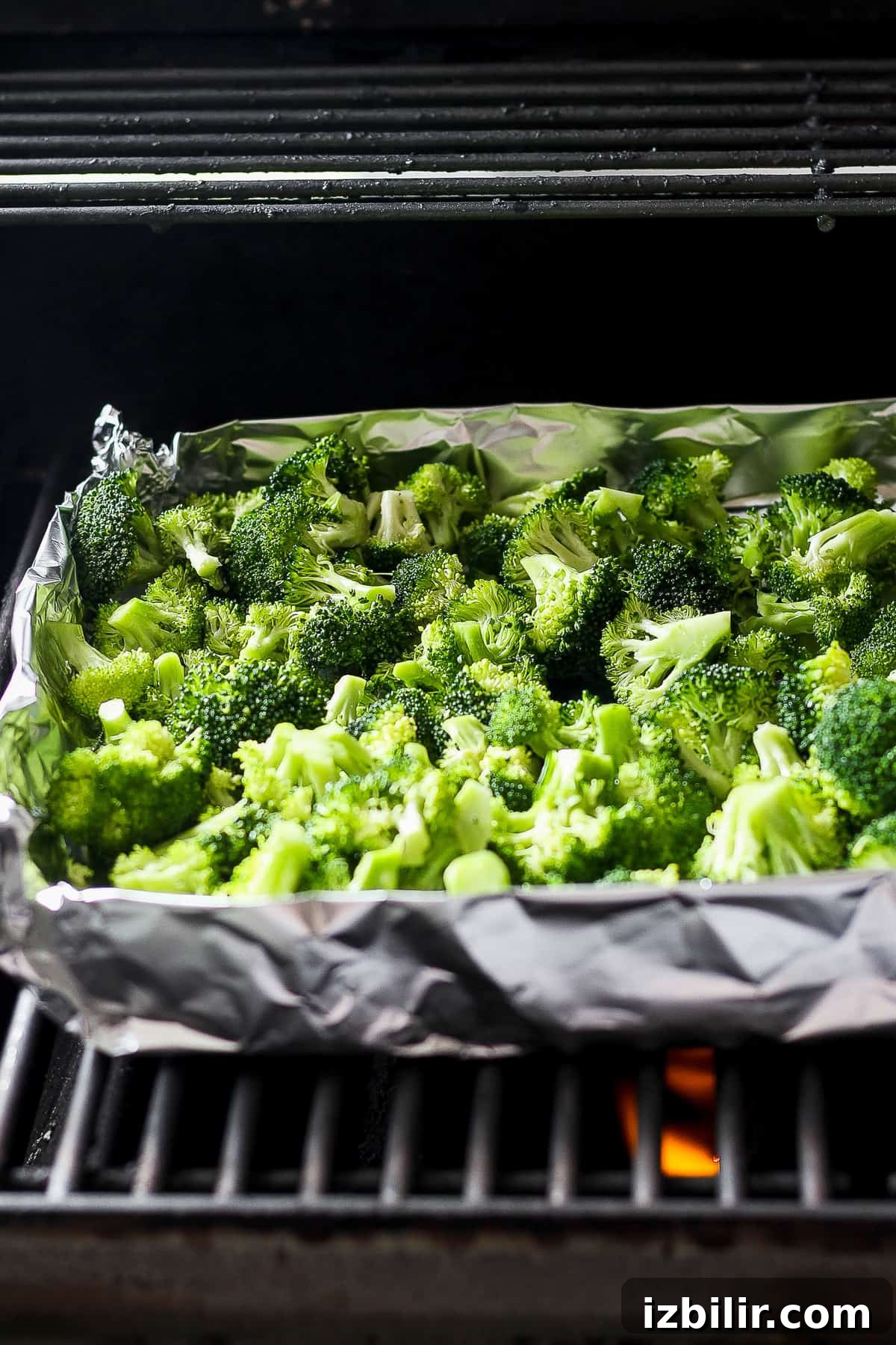 Smoky Grilled Broccoli with Garlic and Lemon 5 a tray of broccoli is cooking in an oven.