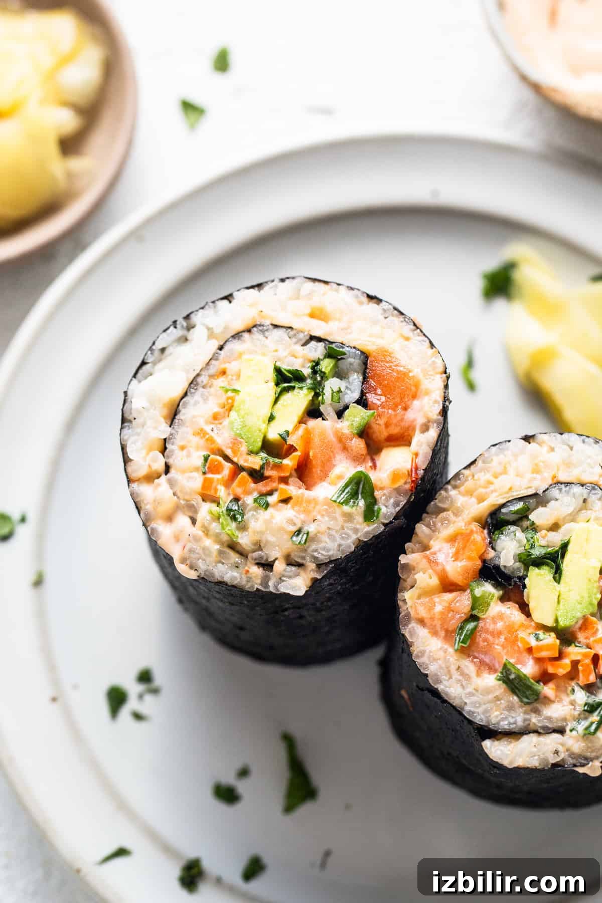 How to Make a Salmon Sushi Burrito at Home 2 a white plate topped with sushi next to a pineapple.