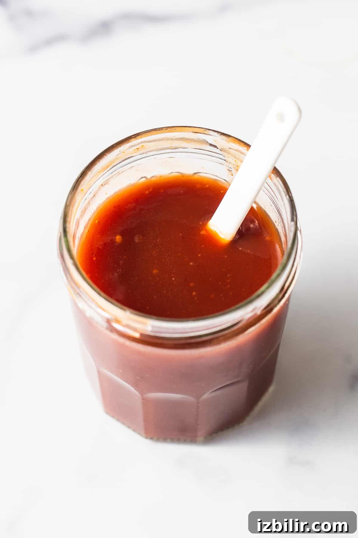 Firecracker Sauce Recipe for Wings, Shrimp and Dips 2 Firecracker sauce in a jar with a spoon.