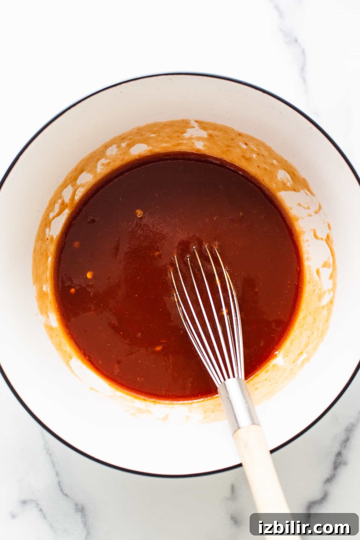 Firecracker Sauce Recipe for Wings, Shrimp and Dips 4 Firecracker sauce in a bowl with a whisk.