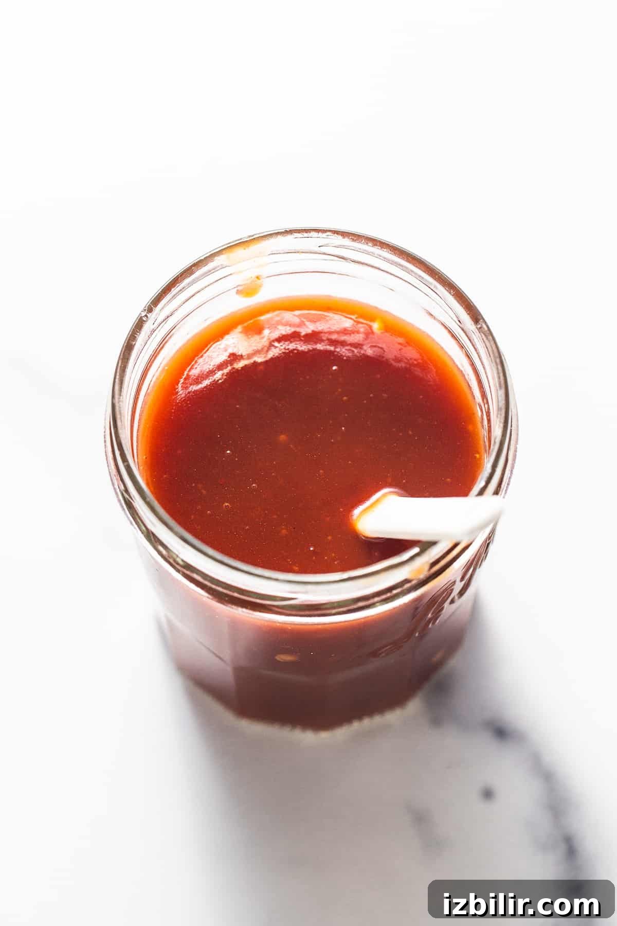Firecracker Sauce Recipe for Wings, Shrimp and Dips 6 A jar of firecracker sauce with a spoon.