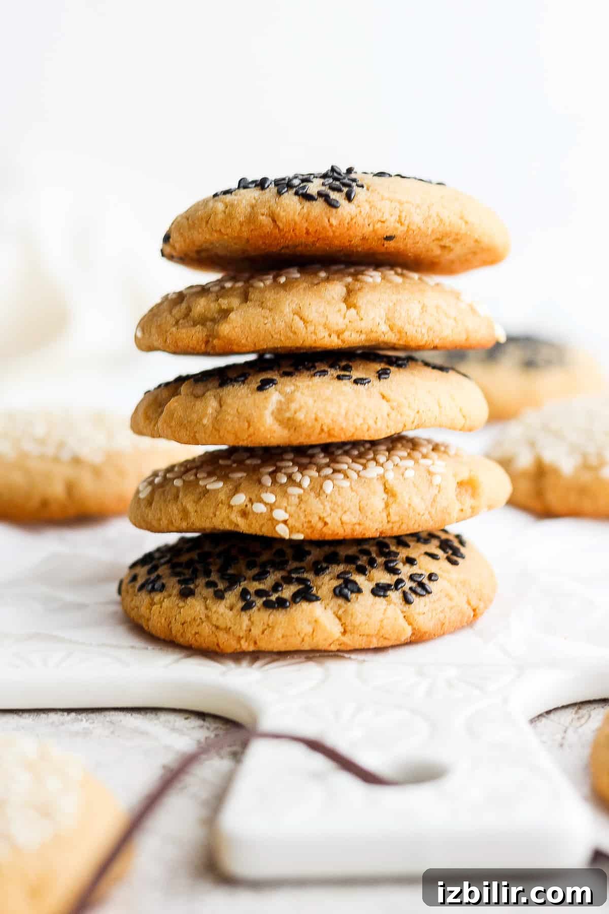 Chewy Tahini Cookies Recipe 8 a stack of cookies with sesame seeds on top.