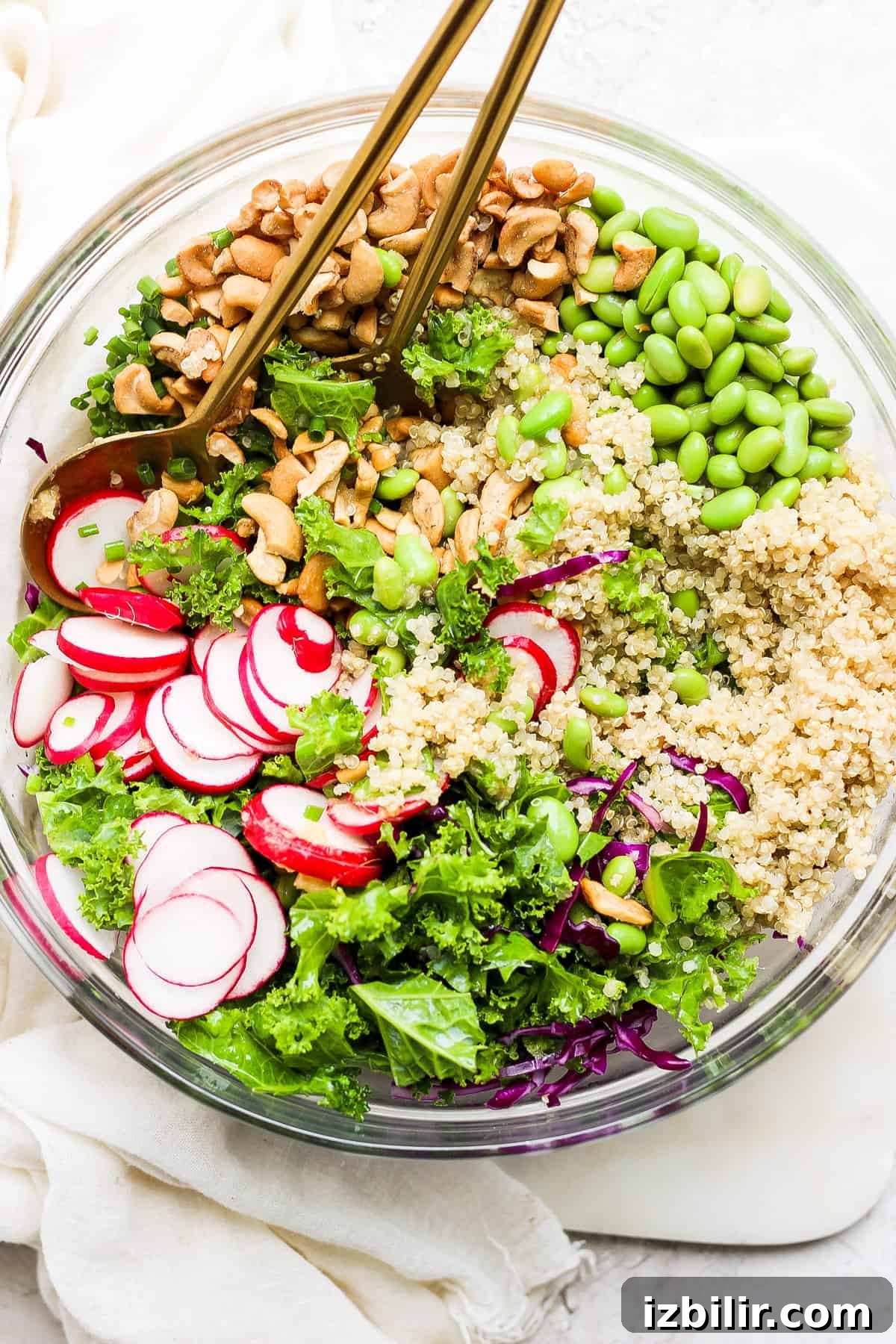 A bowl of quinoa salad with radishes and cashews.