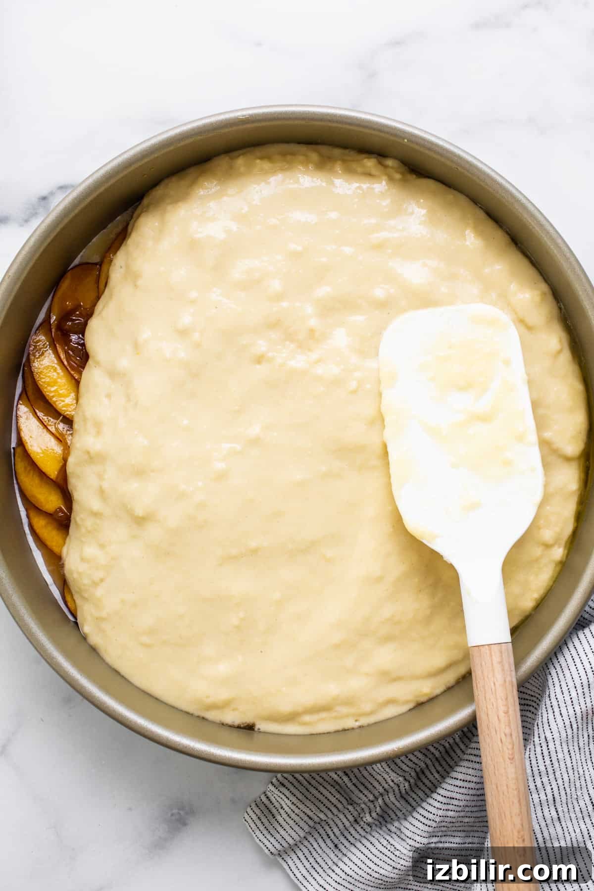 Caramelized Peach Upside Down Cake Recipe 4 Peach cake in a pan with a spatula.