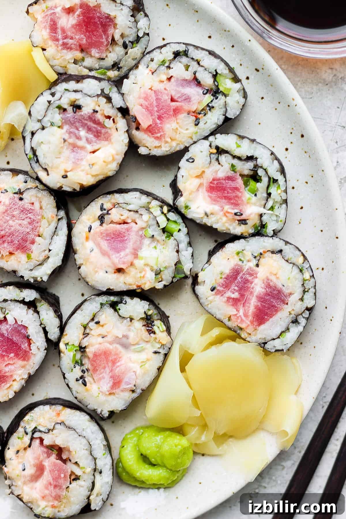 Spicy Tuna Roll Recipe: How to Make at Home 2 a plate of sushi with tuna and cucumber on it.