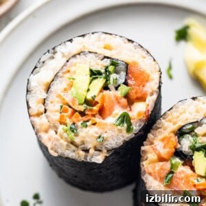 Spicy Tuna Roll Recipe: How to Make at Home 7 two sushi rolls on a plate with a lemon wedge.