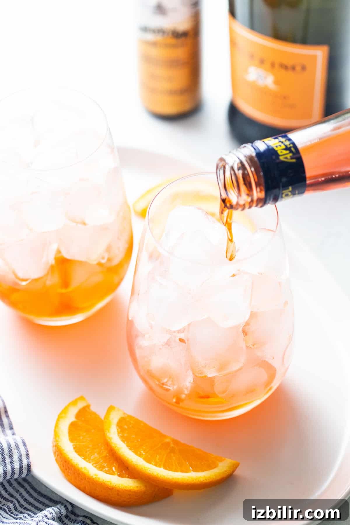 Aperol being poured into a glass for aperol spritz.