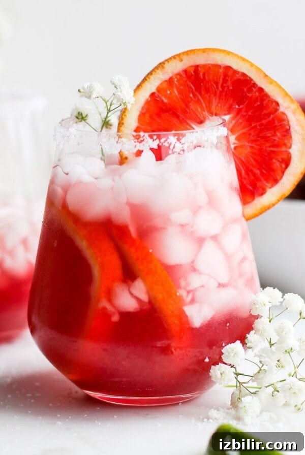Two glasses of Blood Orange Margarita on a white plate.