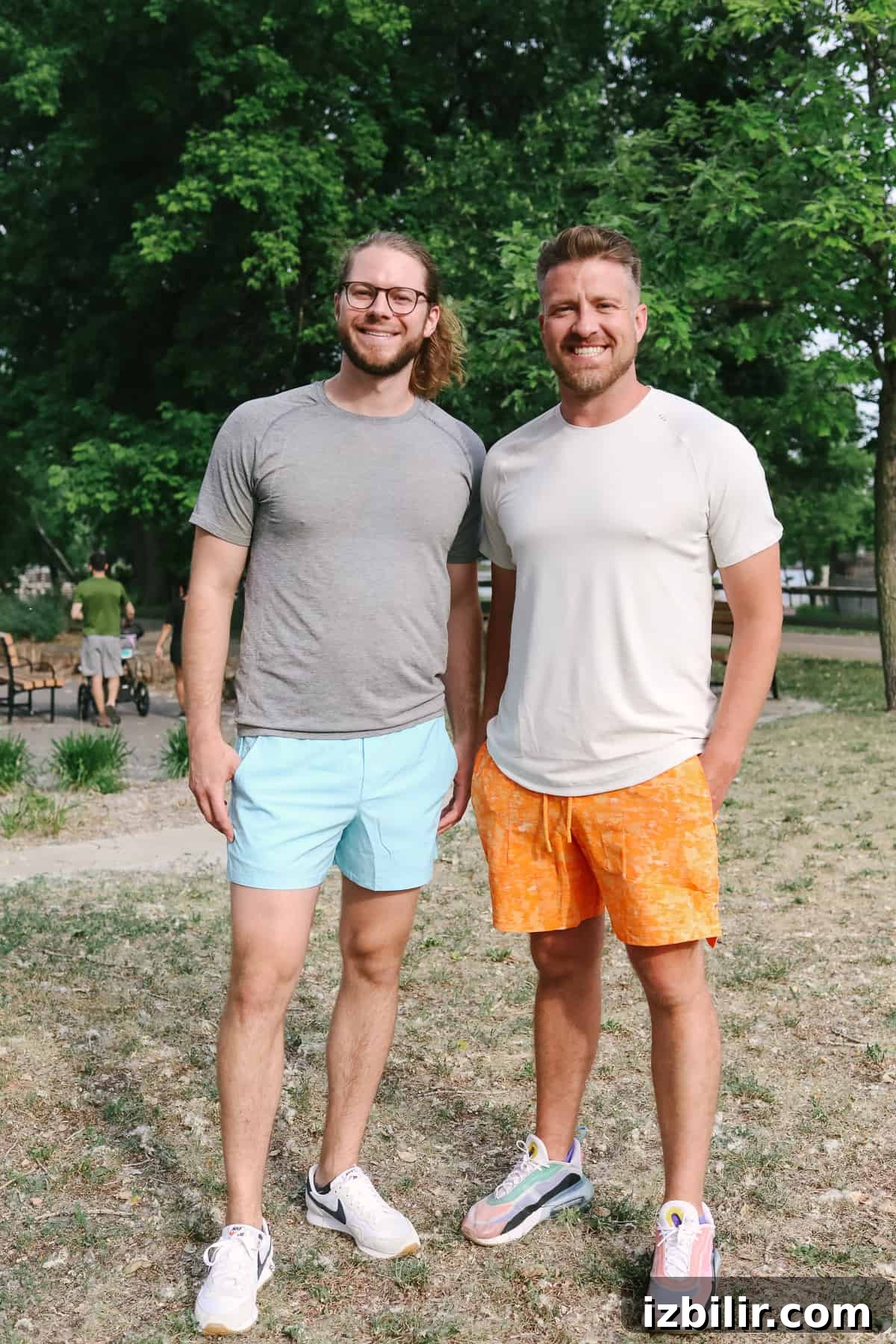 Two men standing side by side wearing casual athletic shorts.