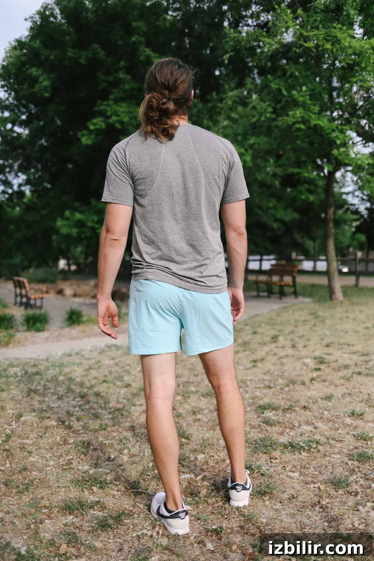 Man in field wearing running shorts.