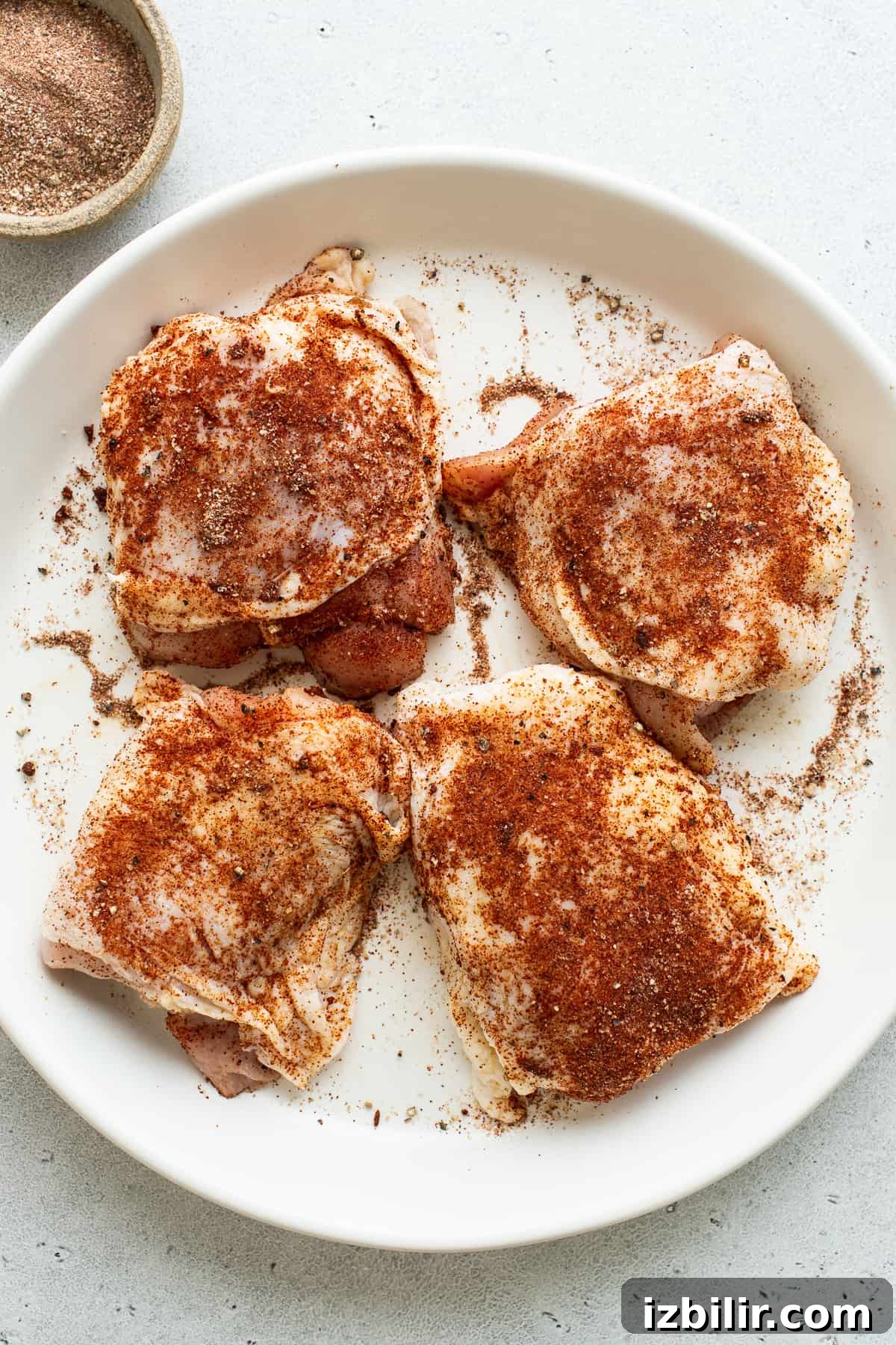 Crispy Cast-Iron Skillet Chicken Thighs 3 Seasoned chicken thighs on a plate