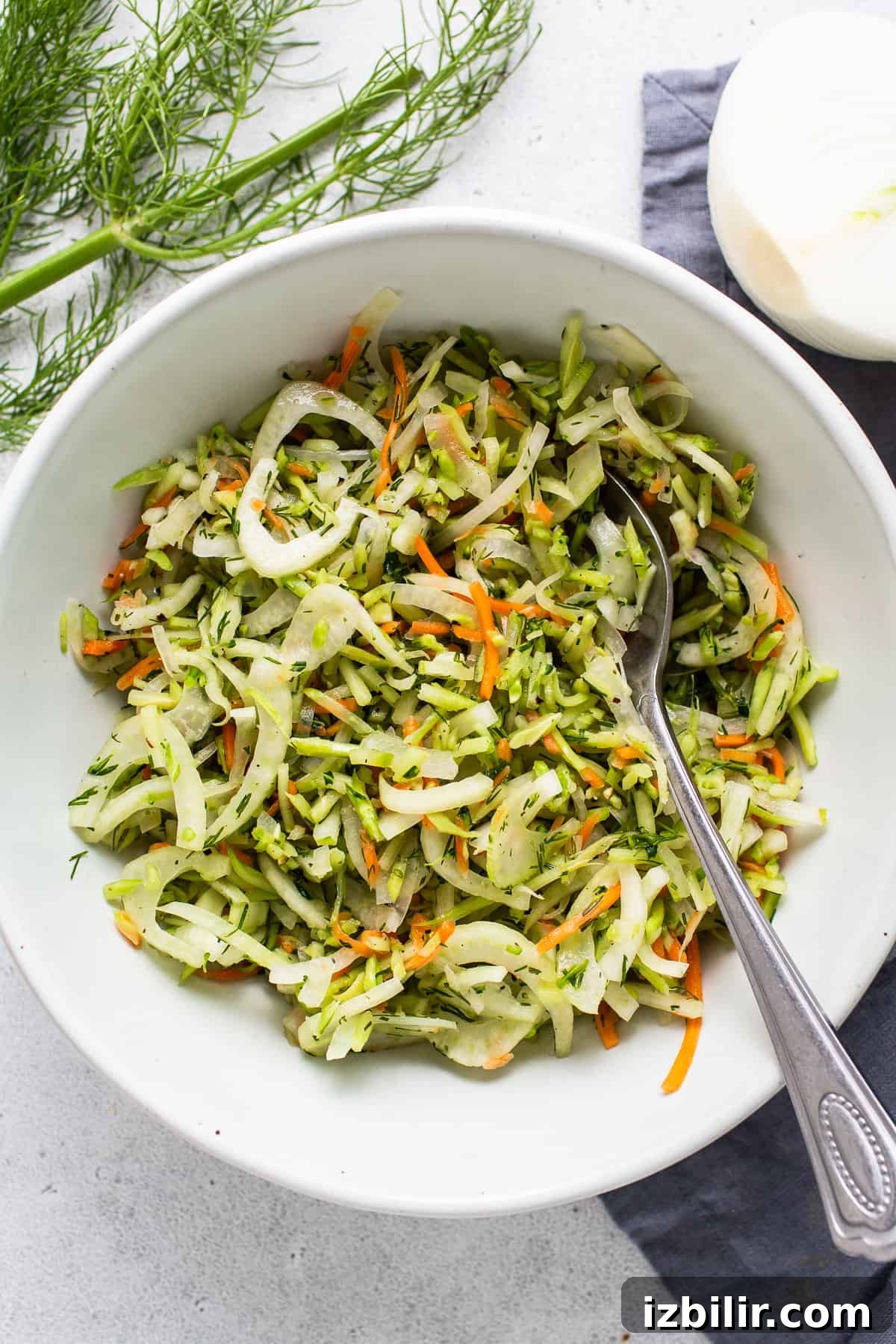 A bowl of dill slaw with carrots and onions.