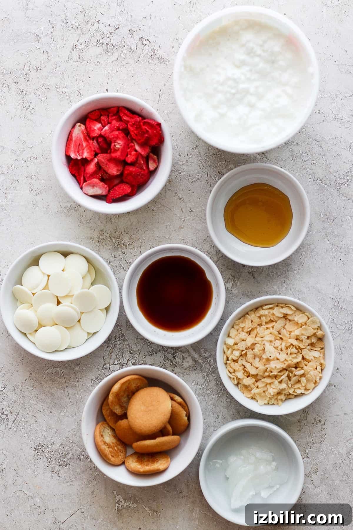 Various bowls of ingredients for a strawberry milkshake.