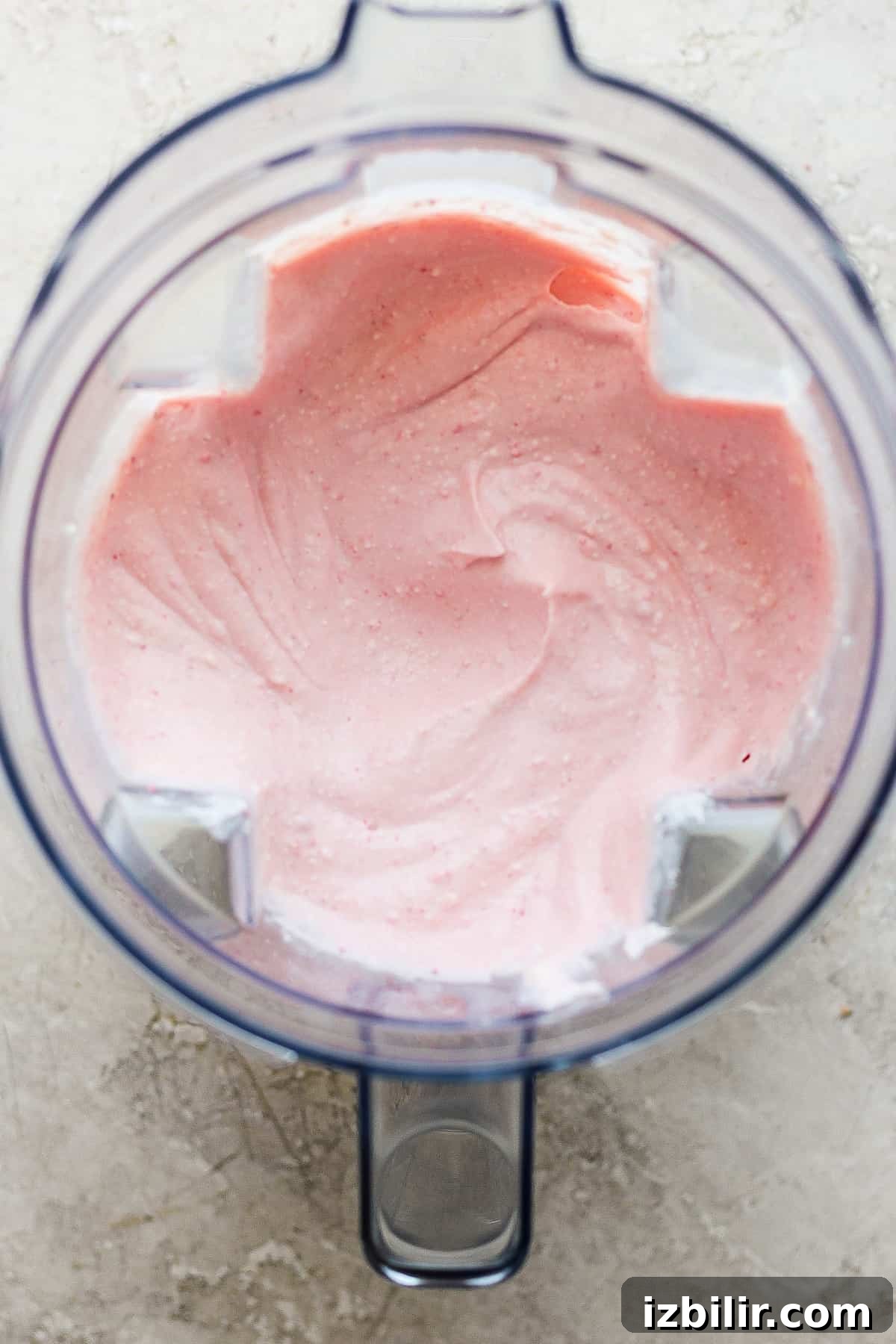 Pink whipped cream in a food processor.