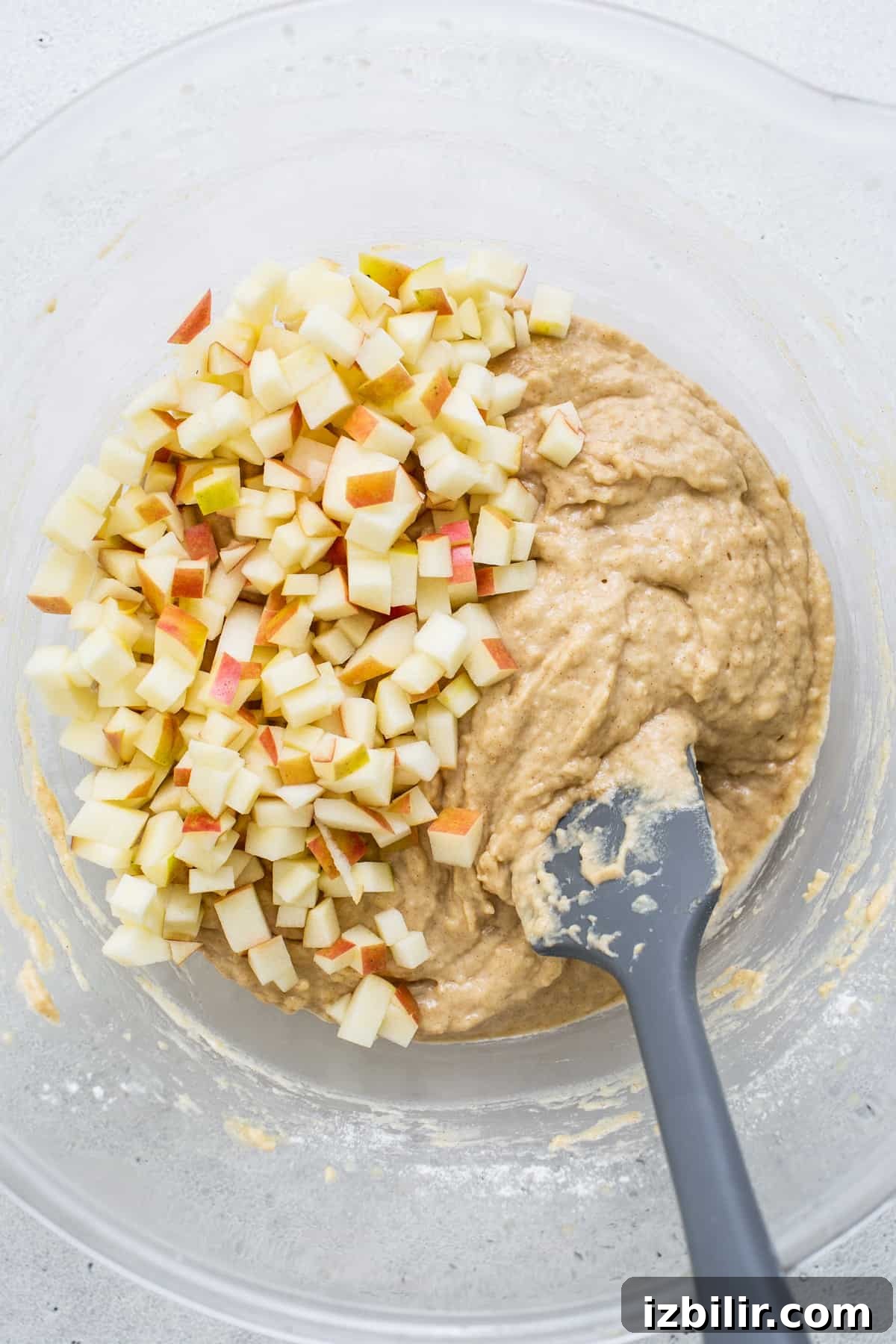 apples in a bowl with a spatula.