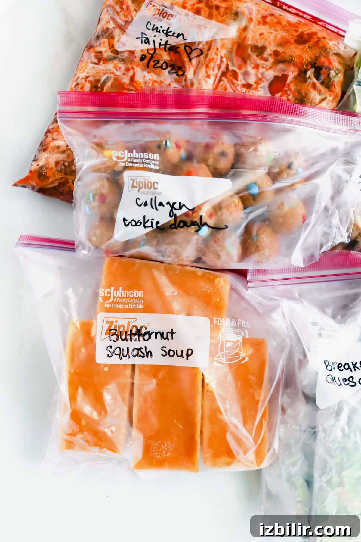 A variety of food in plastic bags on a white surface.