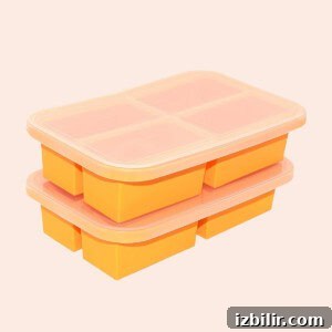 A stack of orange ice cube trays on a beige background.