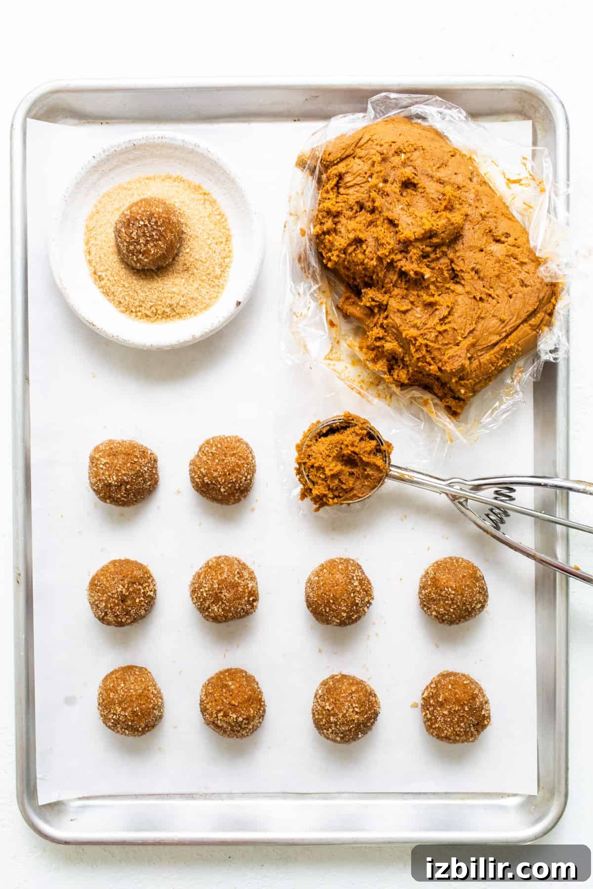 A baking sheet with a tray of doughnuts and a spatula.
