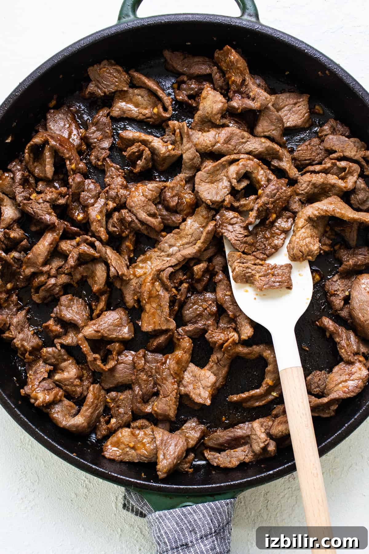 Korean Beef Bulgogi Rice Bowl Recipe 5 Beef in a skillet with a wooden spoon.