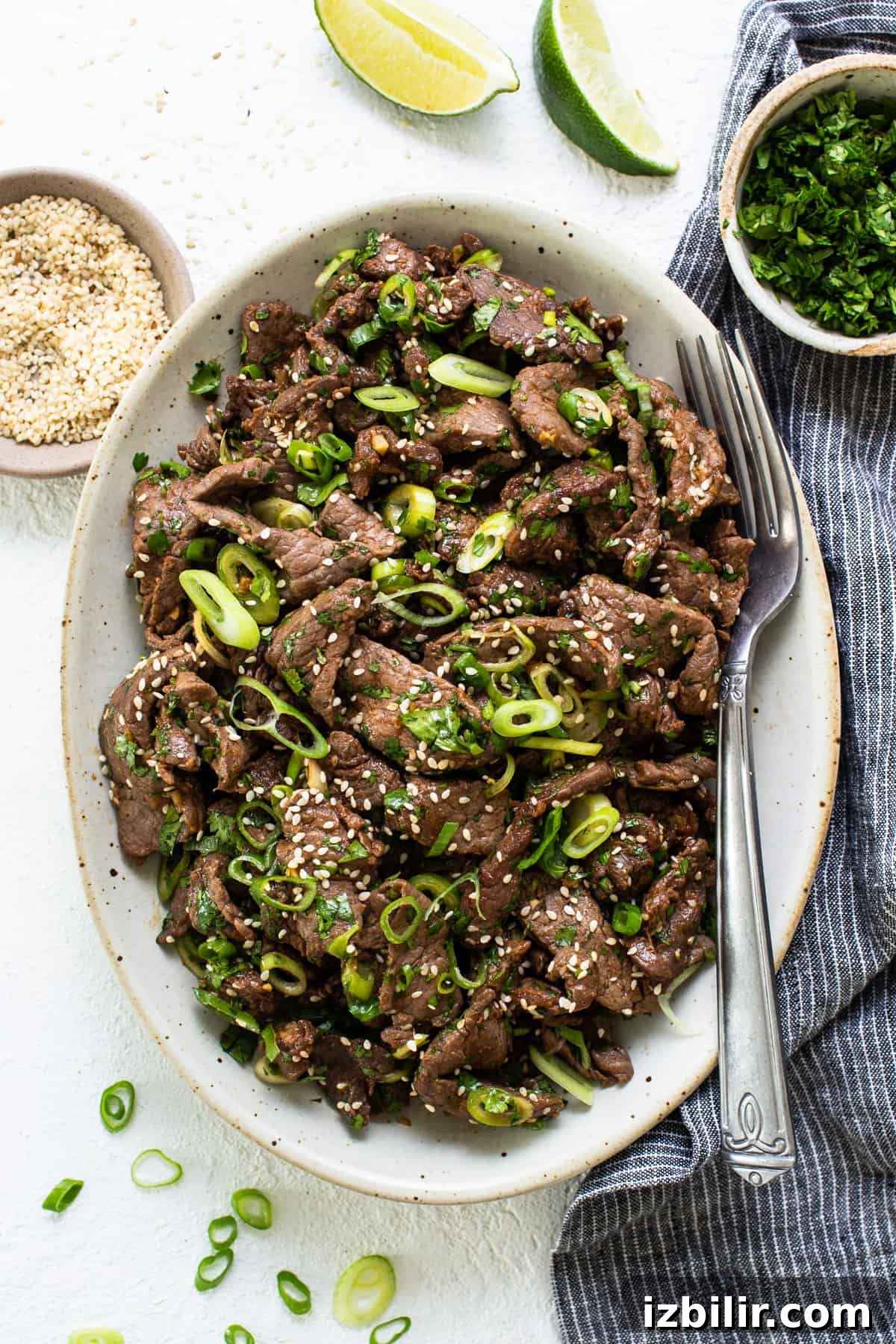 Korean Beef Bulgogi Rice Bowl Recipe 7 A bowl of beef with sesame seeds and green onions.