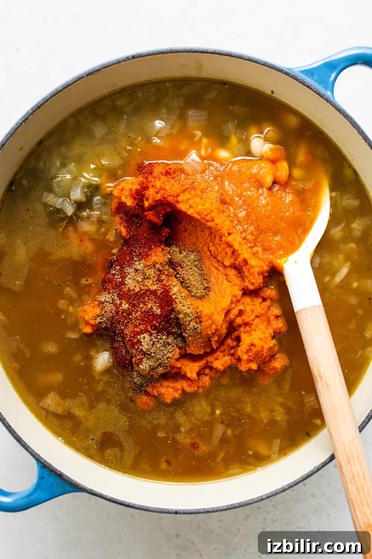 A pot of soup with a spoon in it.