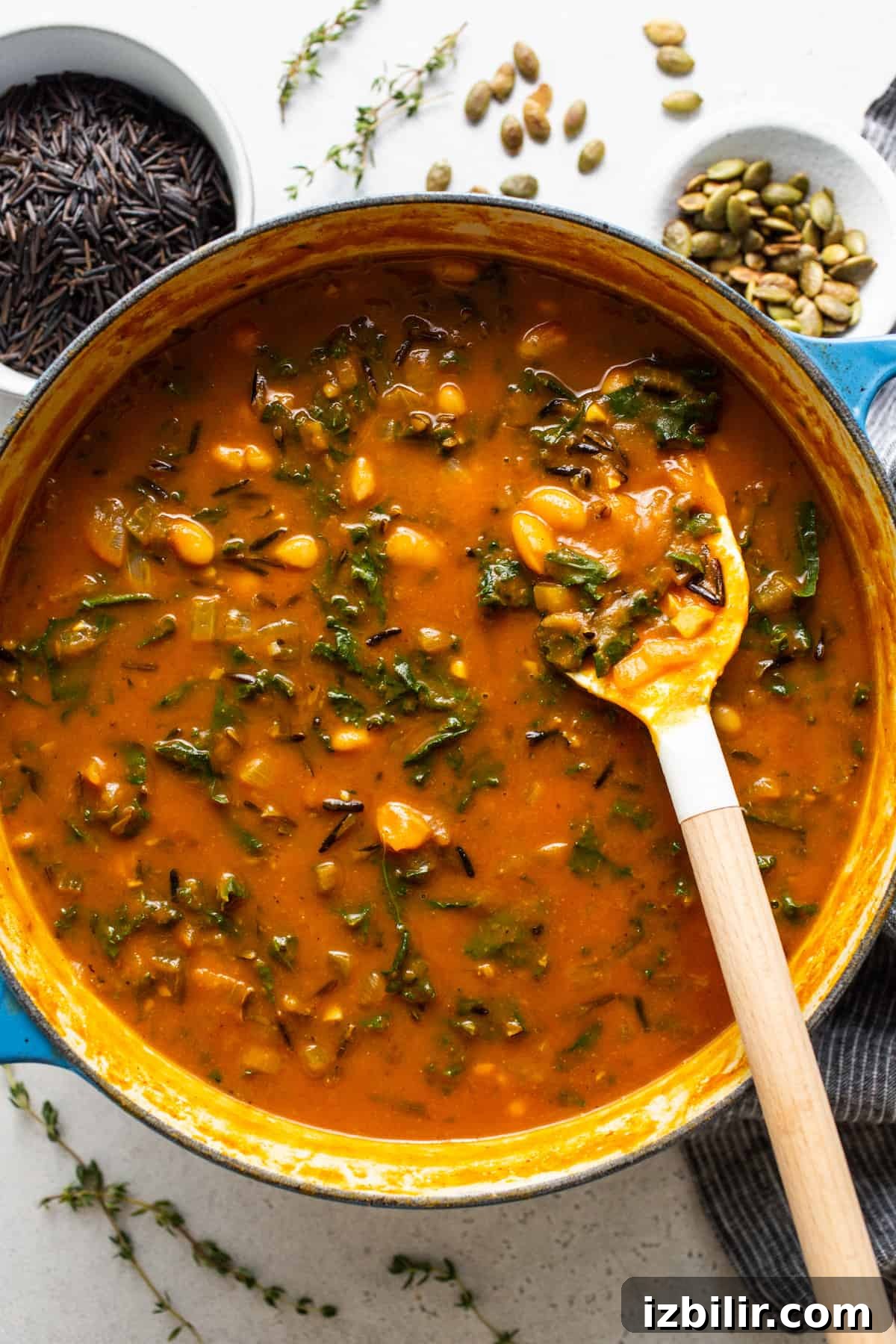 A pot full of soup with a spoon in it.