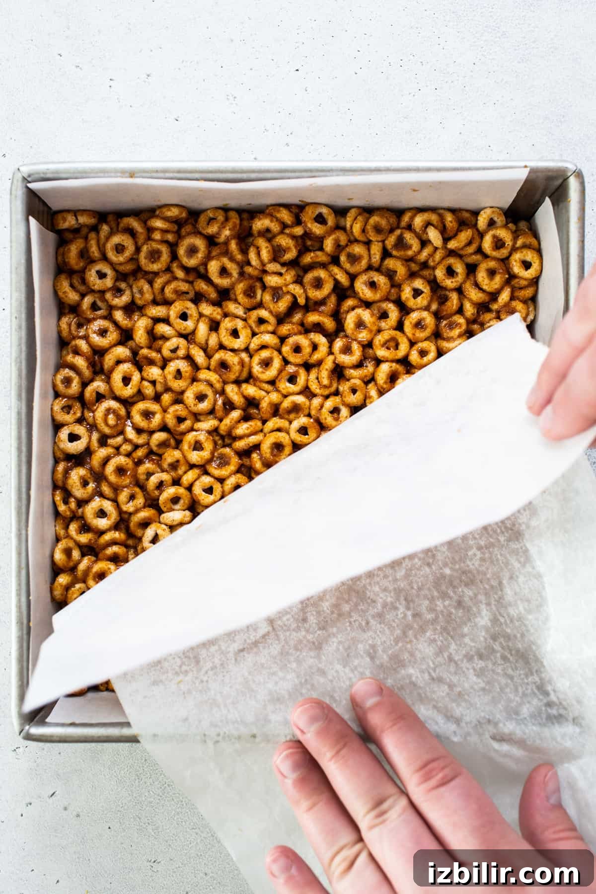 A person putting pretzels in a baking pan.