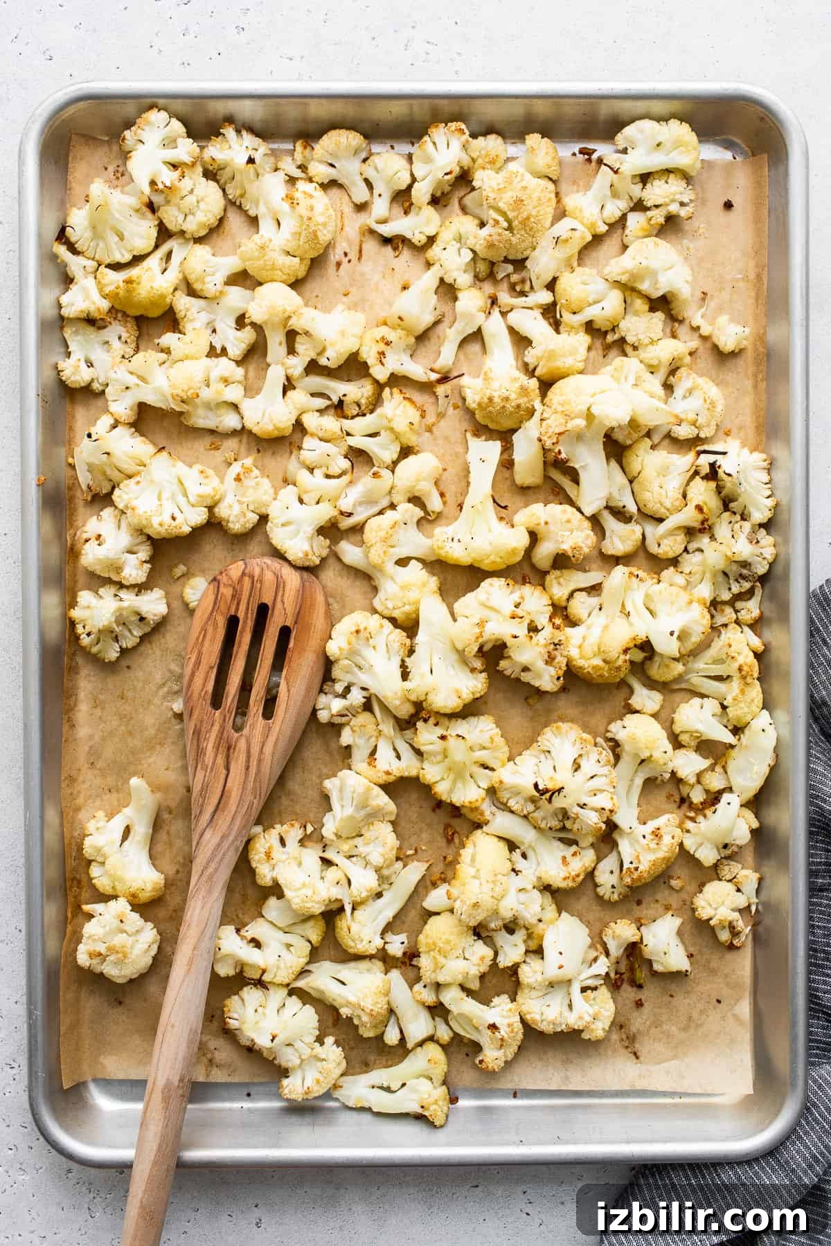 Cauliflower florets on a baking sheet.
