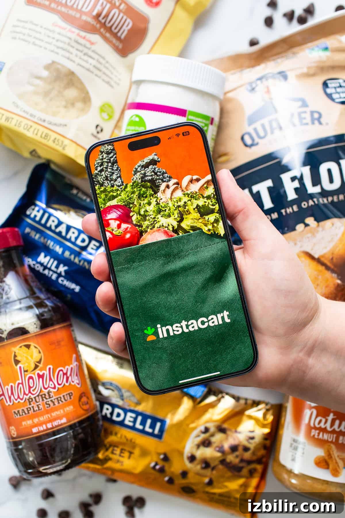 No-Bake Peanut Butter Twix Cups Recipe 3 A person holding a phone next to a bag of food.