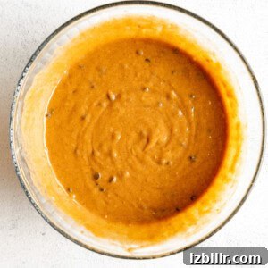 Classic Pumpkin Muffins Recipe with Warm Fall Spices 7 A bowl with a sauce on a white surface.