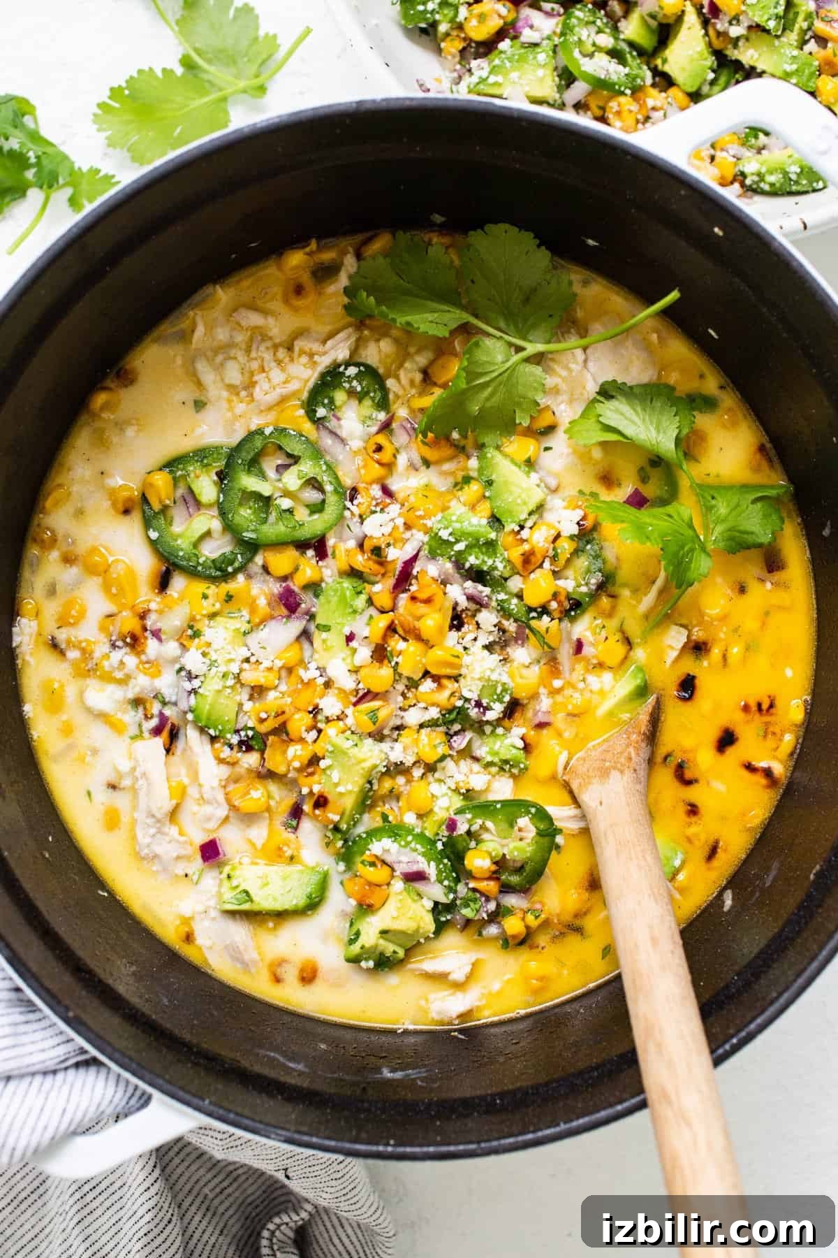 Fit Foodie Cooking Club October 2023: Recipes and Menus 4 Chicken and corn soup in a pan with a wooden spoon.