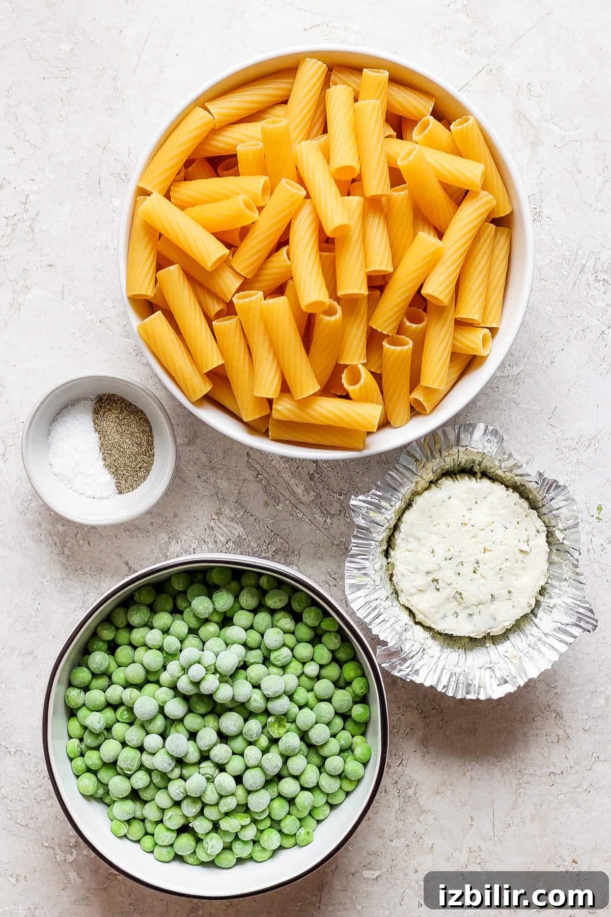 Creamy One-Pot Boursin Pasta Recipe 4 A bowl of pasta, peas and other ingredients.