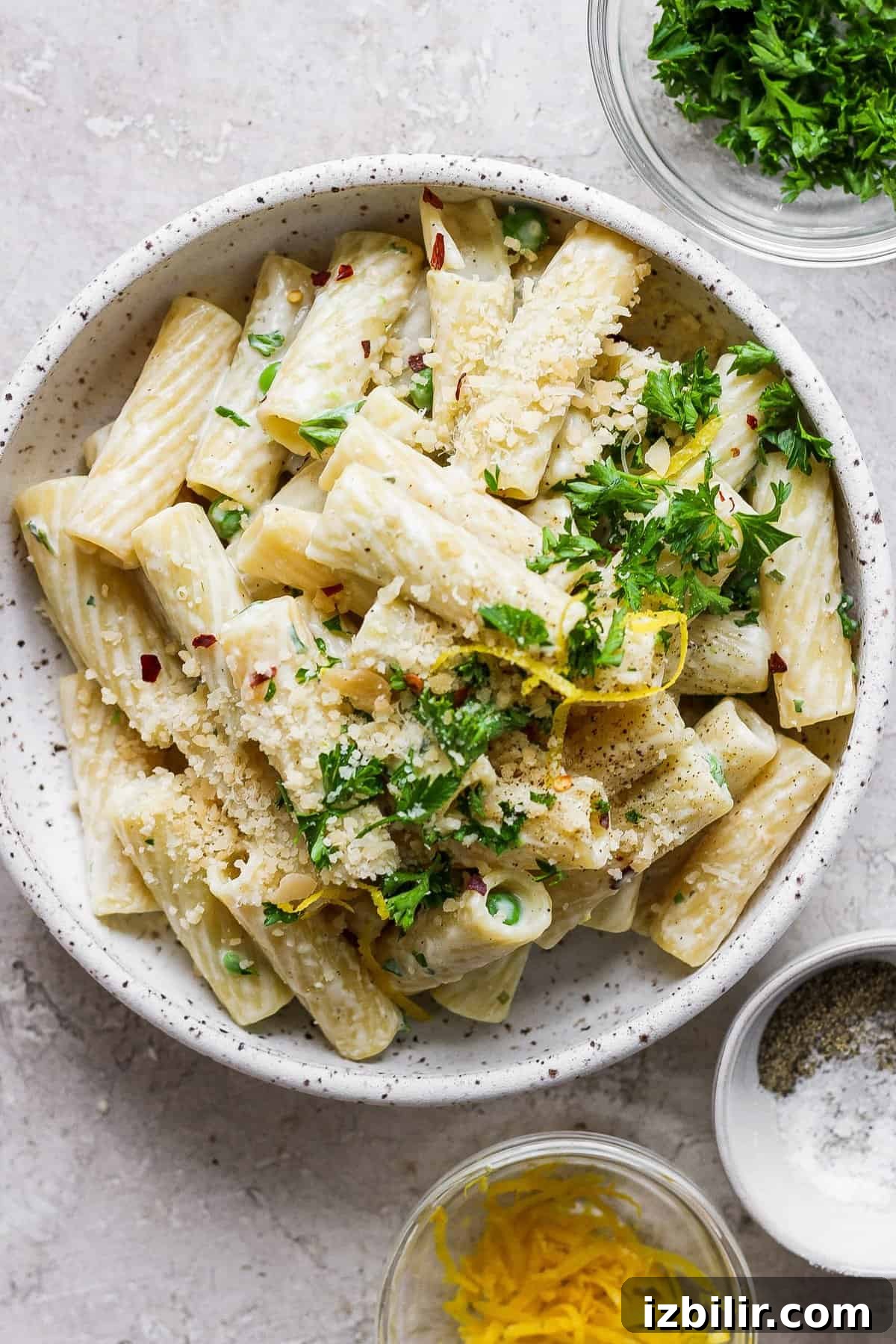 Creamy One-Pot Boursin Pasta Recipe 7 Penne pasta with lemon and herbs in a white bowl.