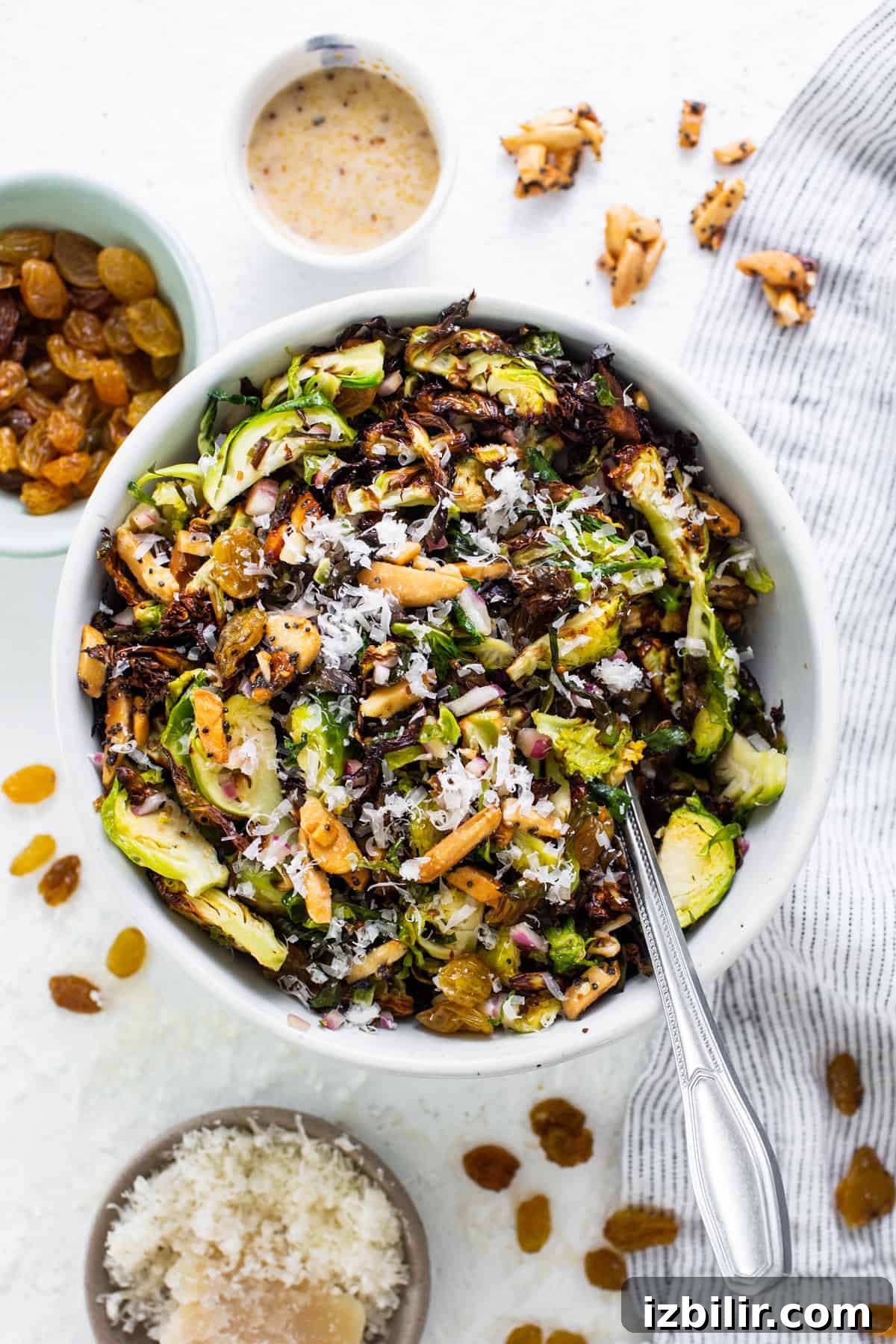 Crispy Air Fryer Brussels Sprouts Salad 2 A bowl of brussels sprouts salad with nuts and raisins.