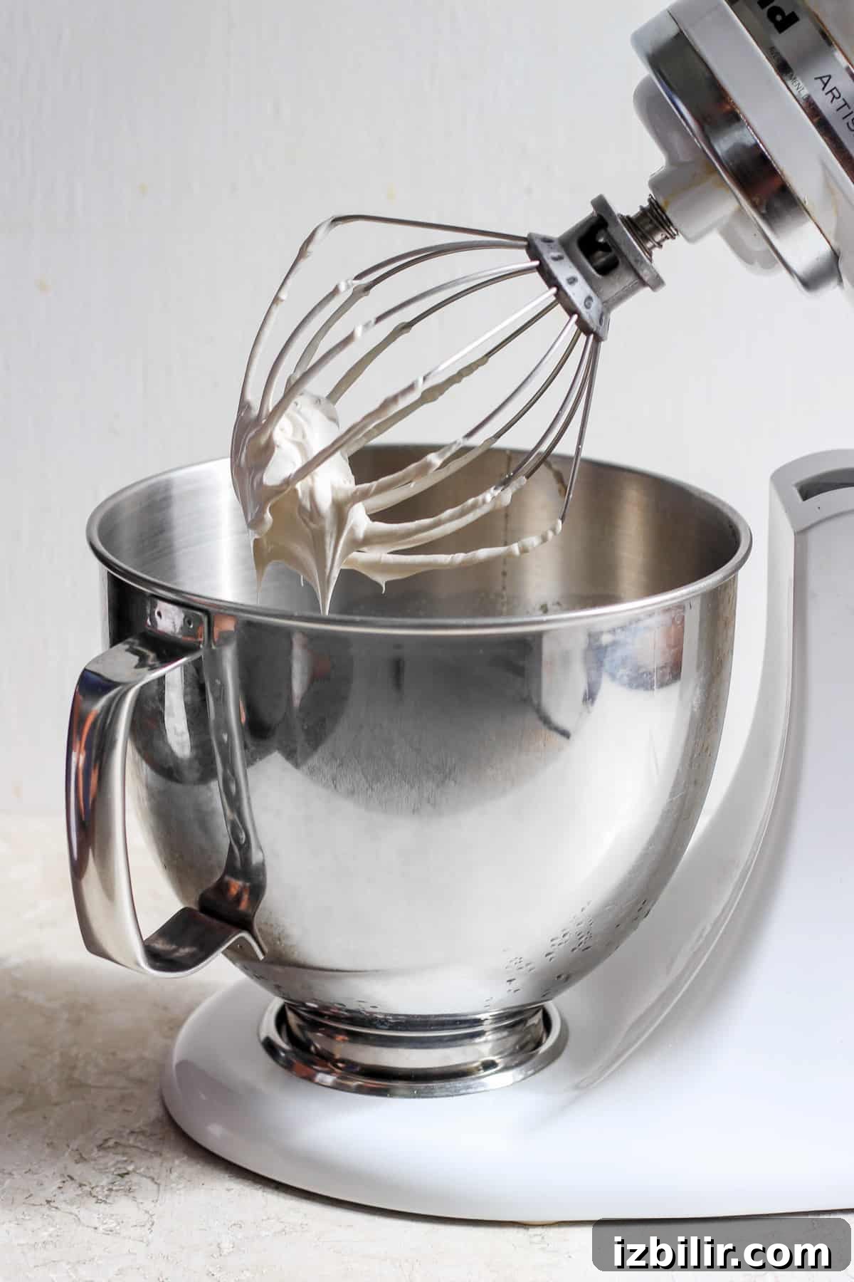 How to Make Brown Sugar Swiss Meringue 5 A white mixer with a whisk in it.