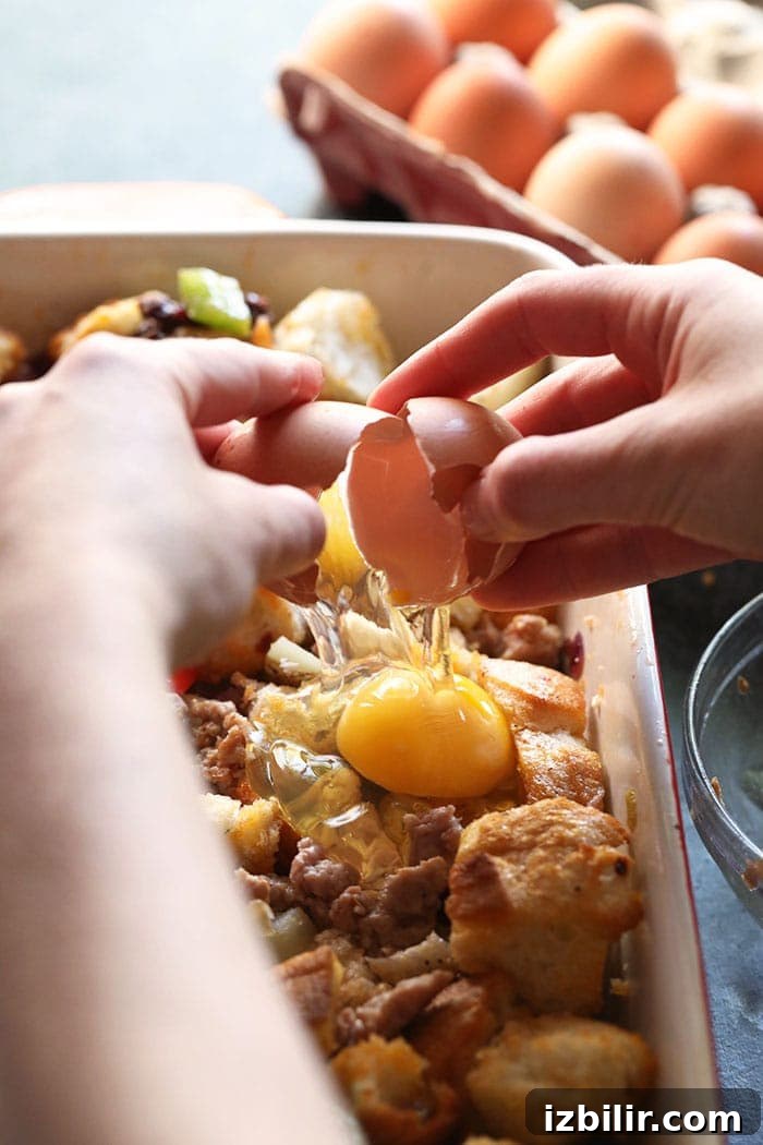 Cracking an egg over casserole mixture two hands cracking an egg onto casserole mixture