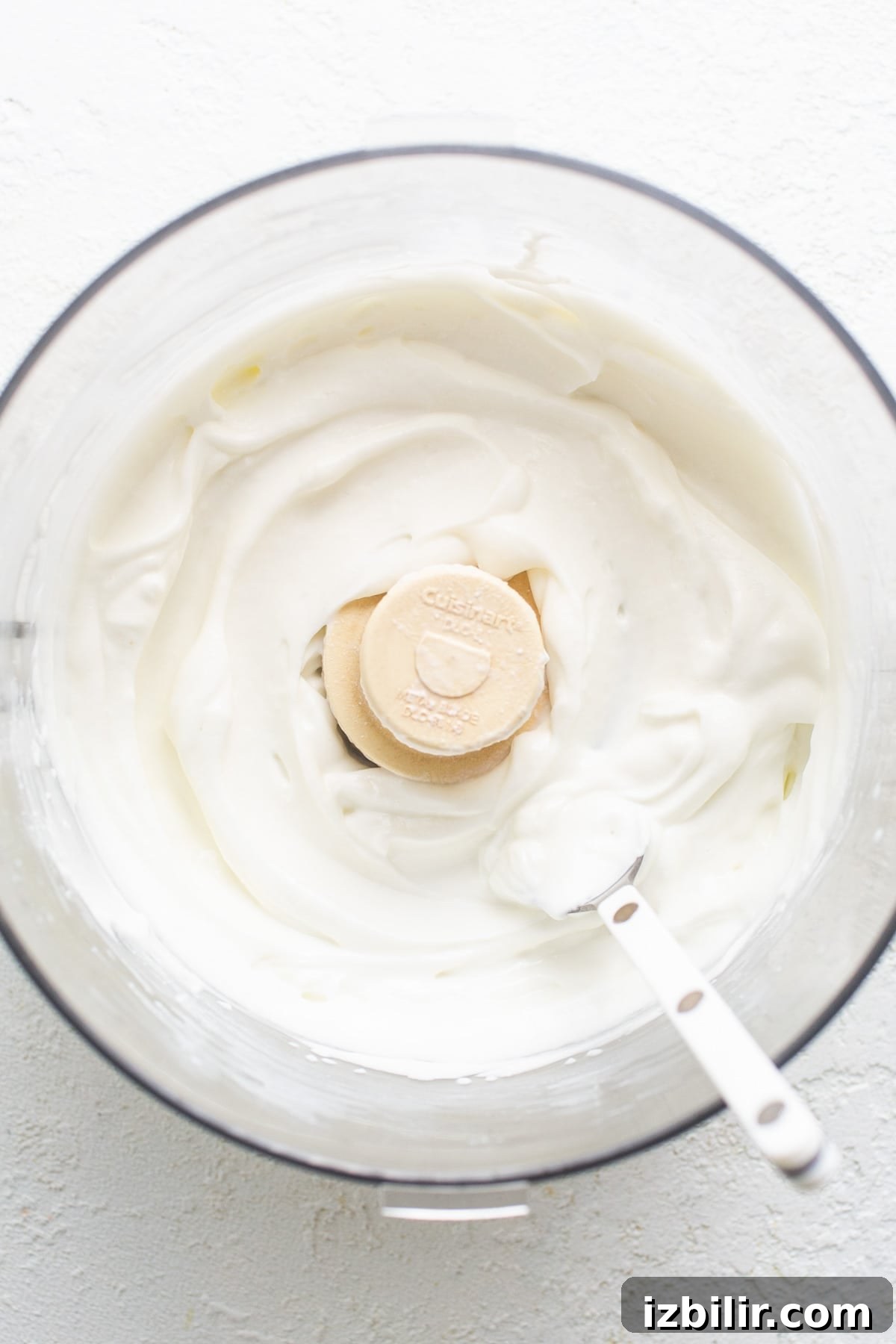 A bowl of whipped cream with a banana slice in it.