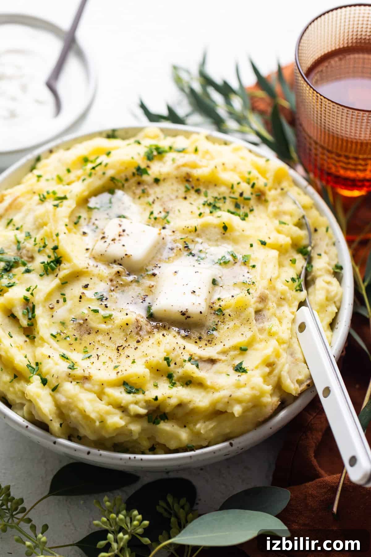 A bowl of mashed potatoes with sour cream and herbs.