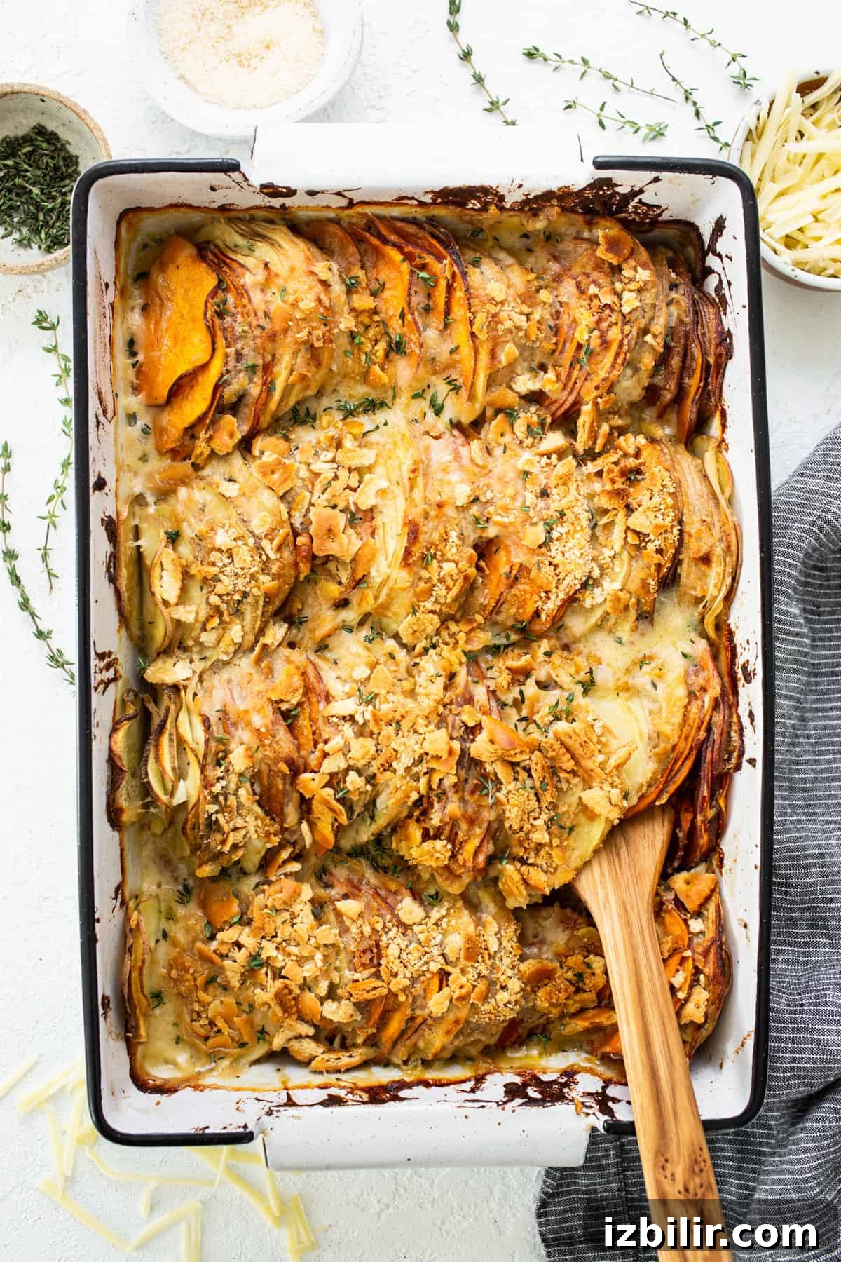 Classic Sweet Potato Au Gratin Recipe 2 Sweet potato casserole in a baking dish with a wooden spoon.