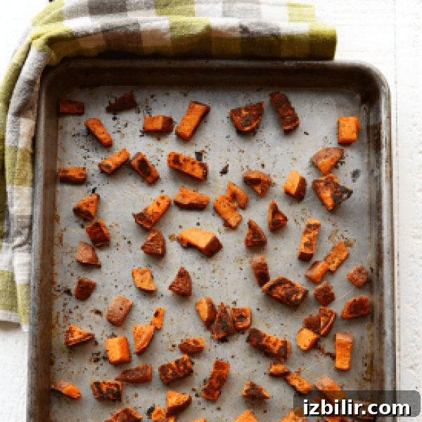 How to Roast Sweet Potatoes for Crispy Edges and Tender Centers 2 Sweet potato cubes on a baking sheet.