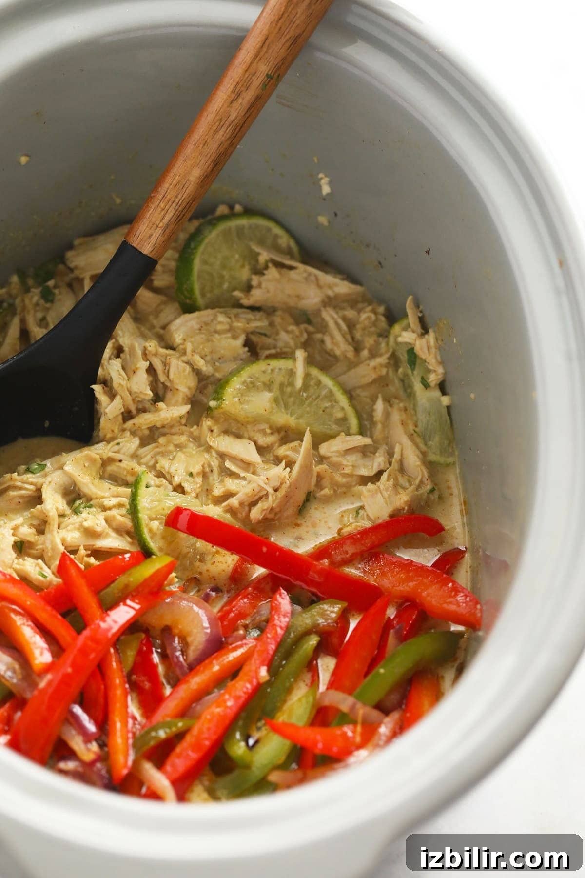 Coconut curry chicken, peppers, and onions in a slow cooker.