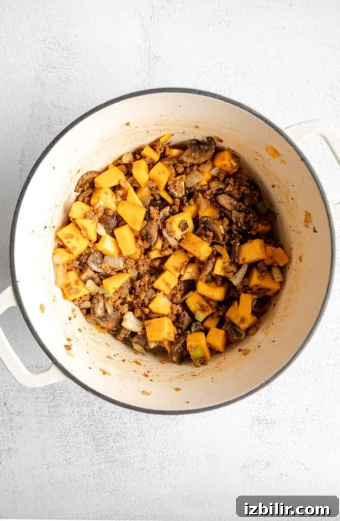 Roasted Butternut Squash and Quinoa Stuffing 4 A white pot filled with squash and mushrooms.