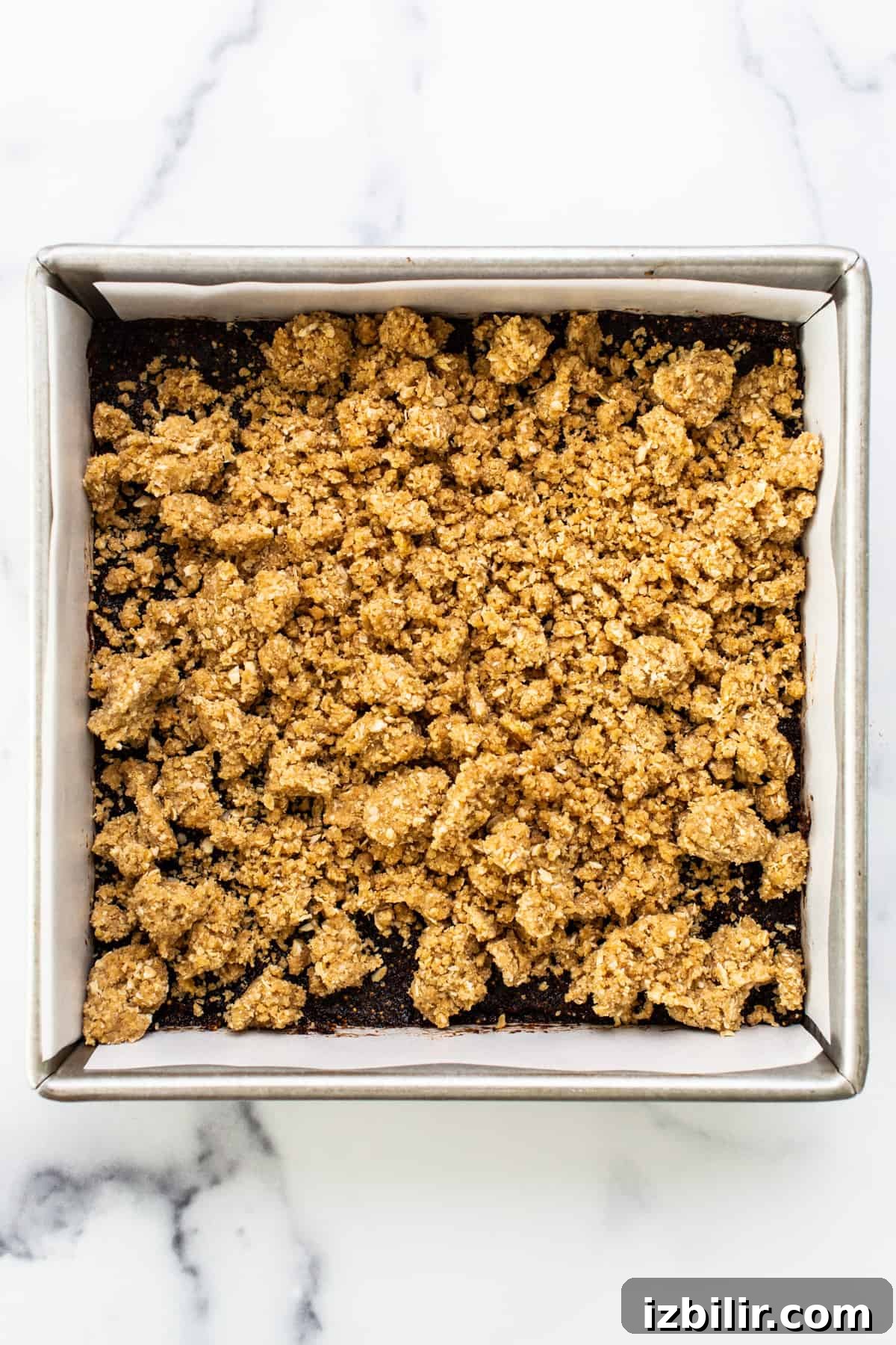 Fig-Filled Oatmeal Crumble Bars 5 A baking pan with a layer of granola in it.