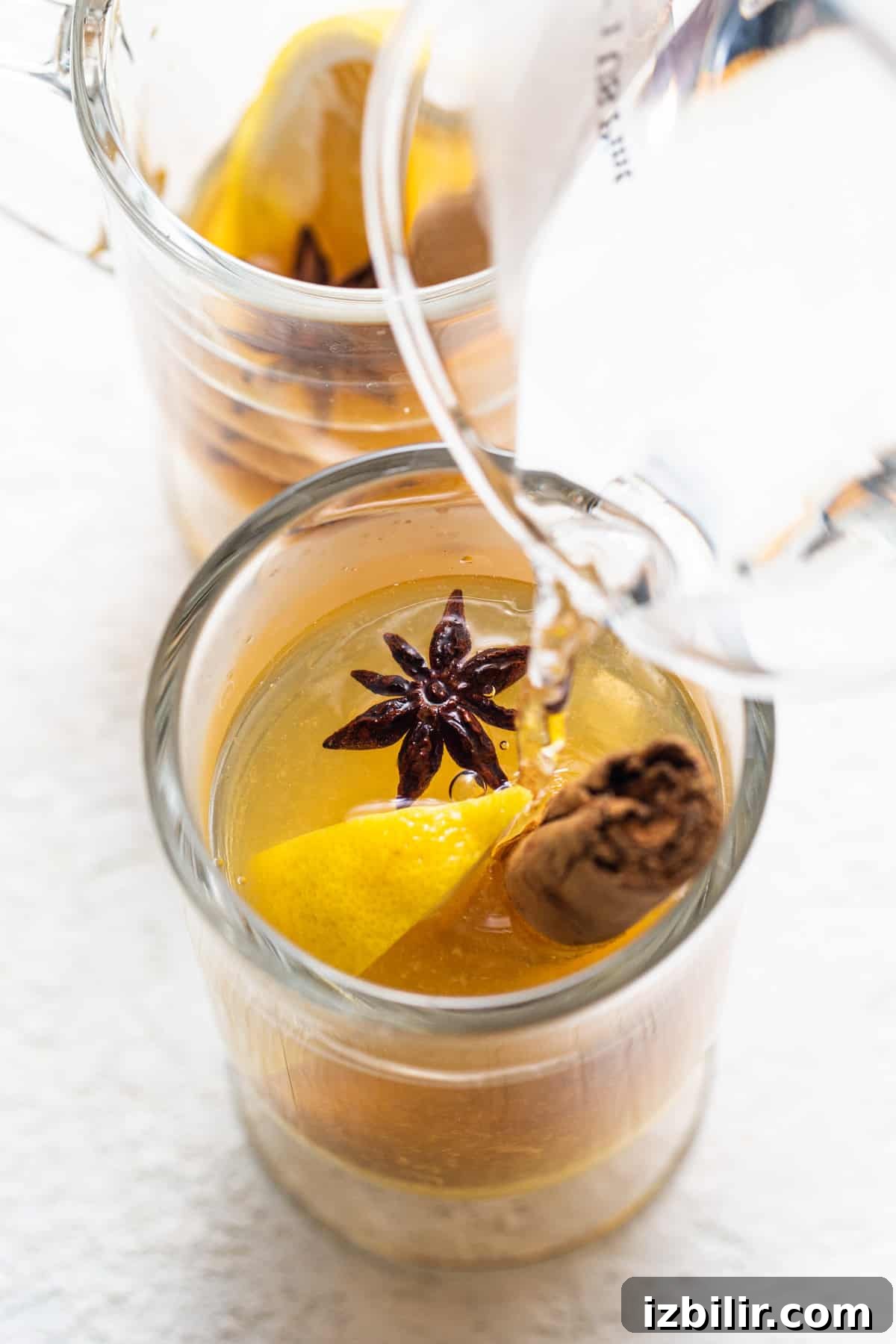 Maple Hot Toddy Recipe: Whiskey, Lemon & Warm Spices 4 A glass with a lemon and star anise in it.