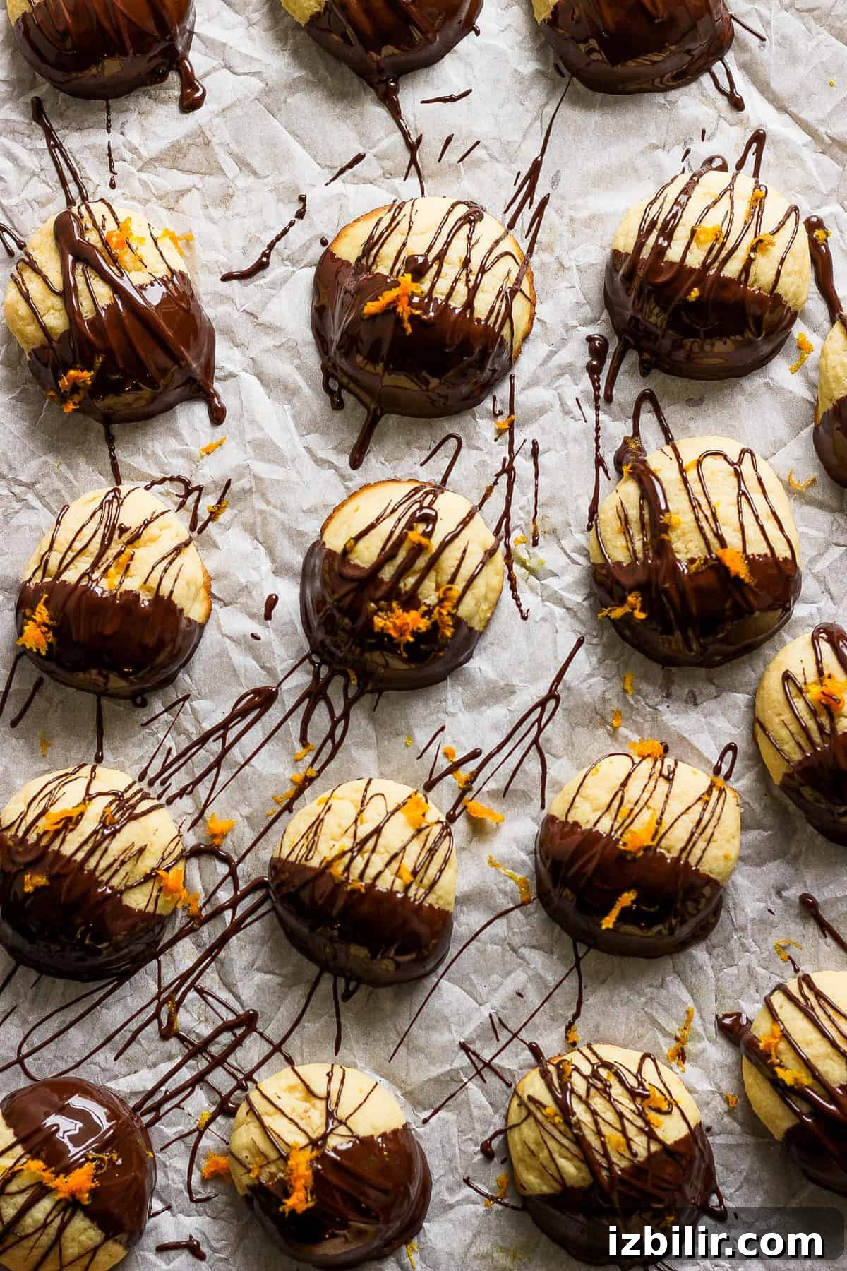 Zesty Chocolate Orange Ricotta Cookies 6 Chocolate-covered cookies arranged on paper.