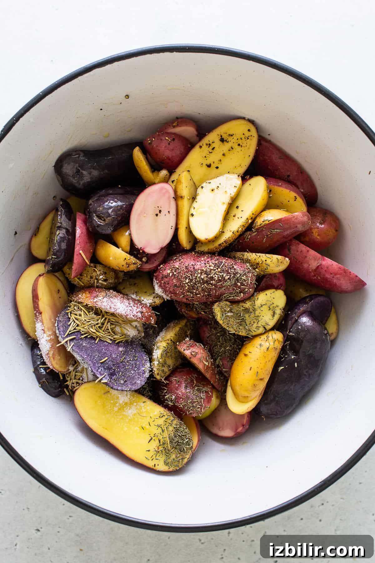 seasoning potatoes in bowl.