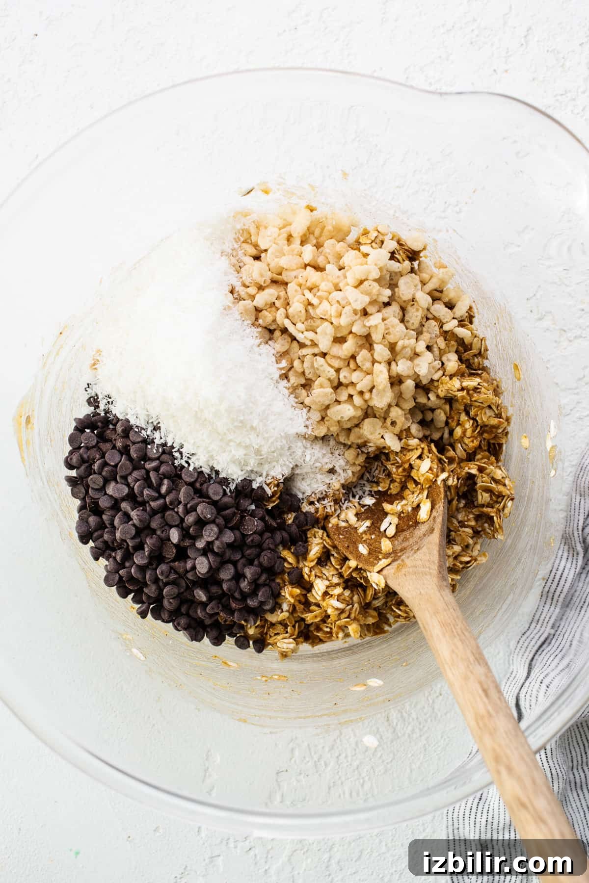 Chewy Flourless Ranger Cookies with Chocolate and Oats 4 Granola and chocolate chips in a bowl with a wooden spoon.